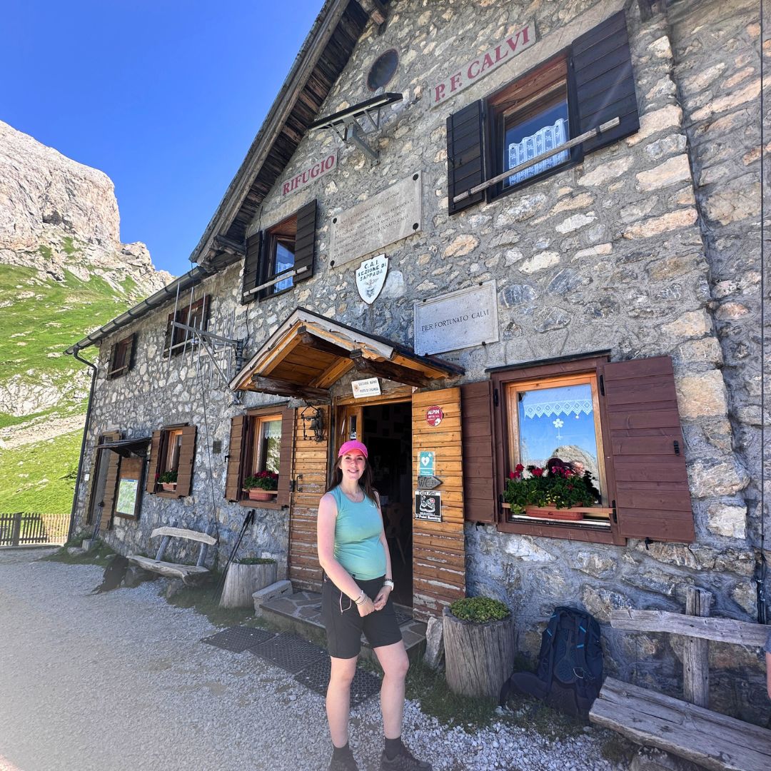 donna incinta davanti a rifugio di montagna